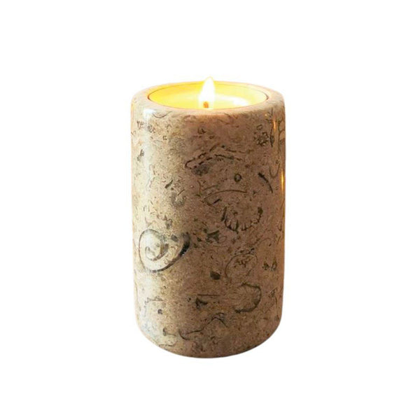 A light brown coloured tea light candle with fossil shapes inside the stone
