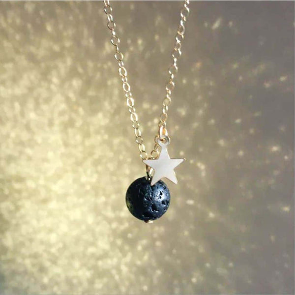Gold star aromatherapy necklace with a gold glitter background