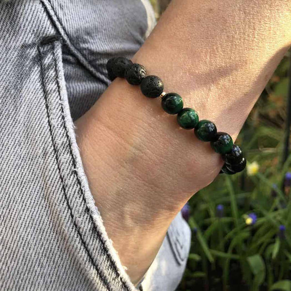 A woman wearing a green tigers eye diffuser bracelet
