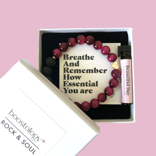 A white gift box with the lid removed showing a diffuser bracelet