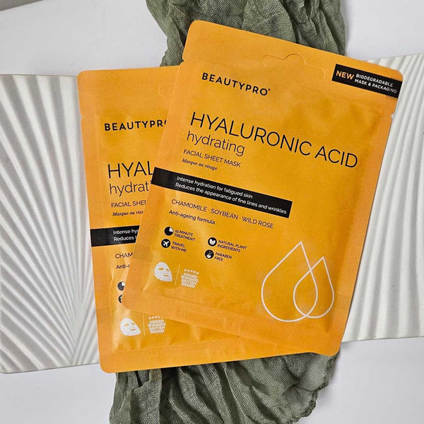 A hydrating sheet face mask pouch on a towel