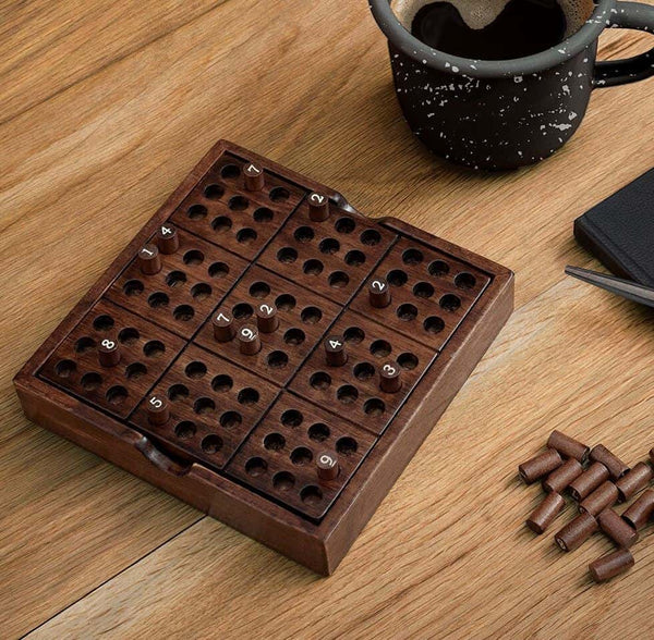 A wooden Sudoku on a table with a coffee cup