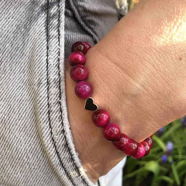 A woman wearing a pink tigers eye bracelet