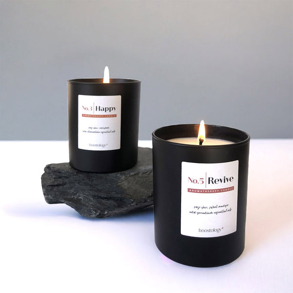 Two black essential oil candles on slate stone