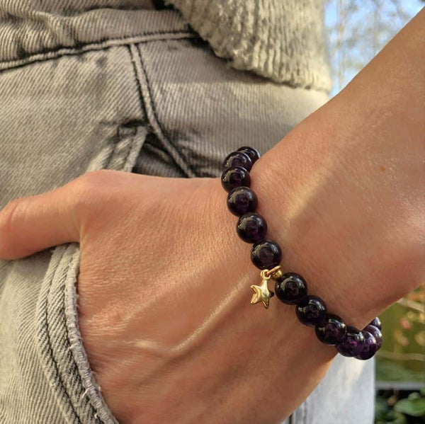 A woman wearing a purple amethyst bracelet