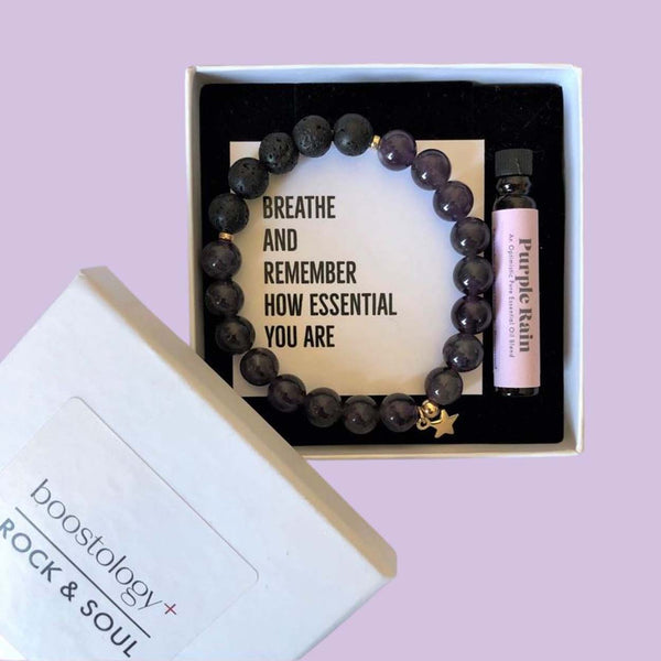 A star charm diffuser bracelet in a white gift box with a bottle of essential oil