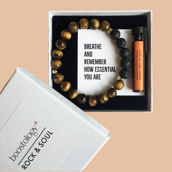 A tigers eye and lava stone diffuser bracelet with the words "breathe and remember how essential you are"