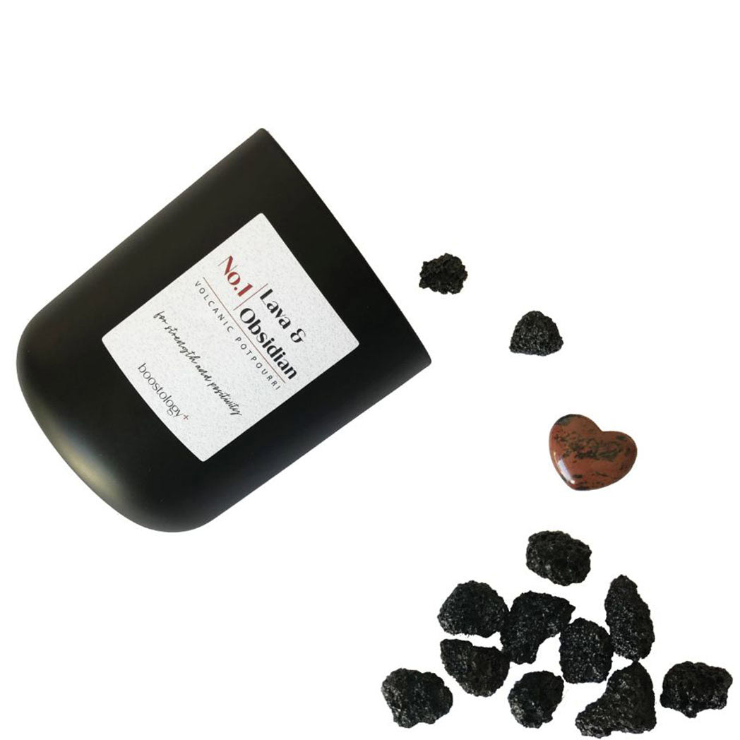 Black lava rocks and a red obsidian stone heart spilling out of the potpourri jar