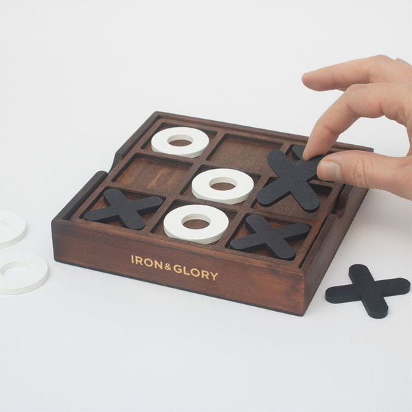 Someone playing with a wooden noughts and crosses