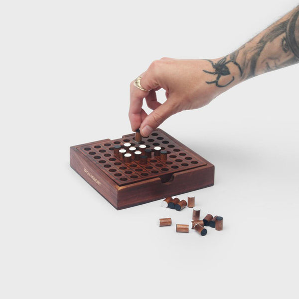 A man with tatoos playing a Reversi game