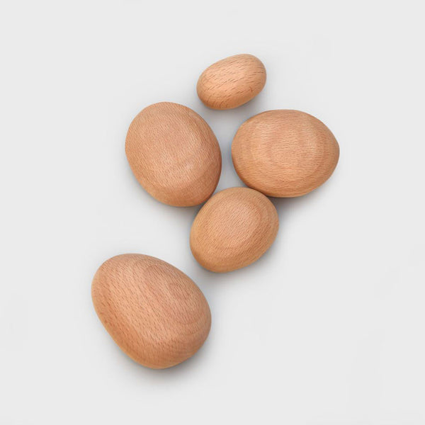 Five large wooden stacking pebbles laid next to each other