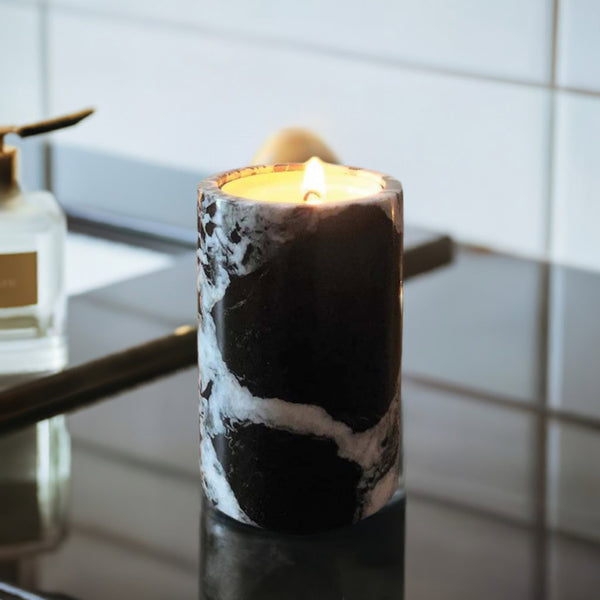 A black marble candle on a black bathroom sink