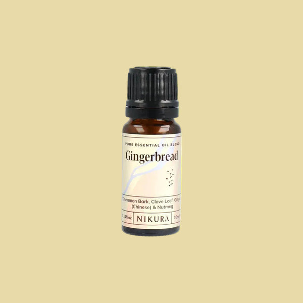 A 10ml amber glass bottle of NIKURA Gingerbread essential oil blend with a black cap and cream-colored label, centered on a plain white background.