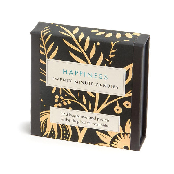 A square box of Happiness Twenty Minute Candles with a black background and gold botanical pattern, featuring cream labels with blue and black text.