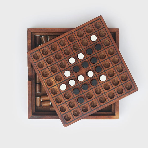 A wooden Reversi game with the lid off showing the playing pieces inside