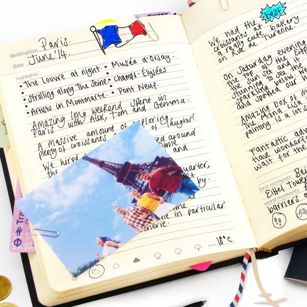 Open notebook with handwritten notes and a photo of the Eiffel Tower.