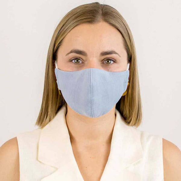 A woman wearing a blue linen 3 layer face mask