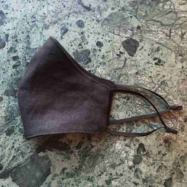 Black Linen Face Mask On Green Marble Top