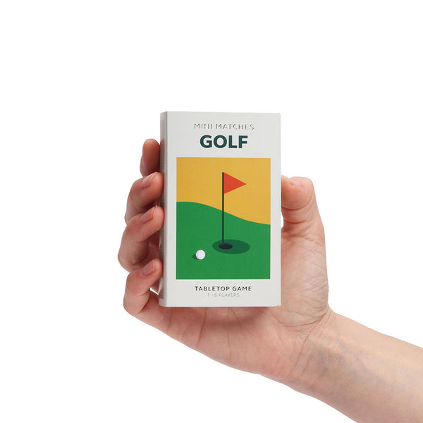 A hand holding a mini matches golf gift box, on a white background