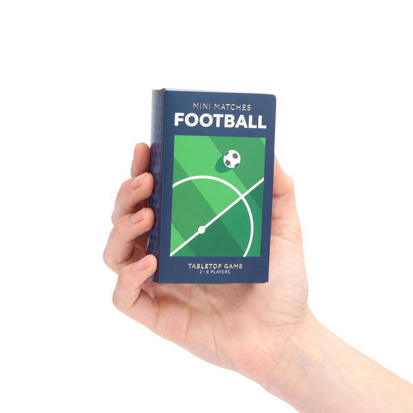 Hand holding a 'Football Mini Matches' box with a green and blue design on a white background