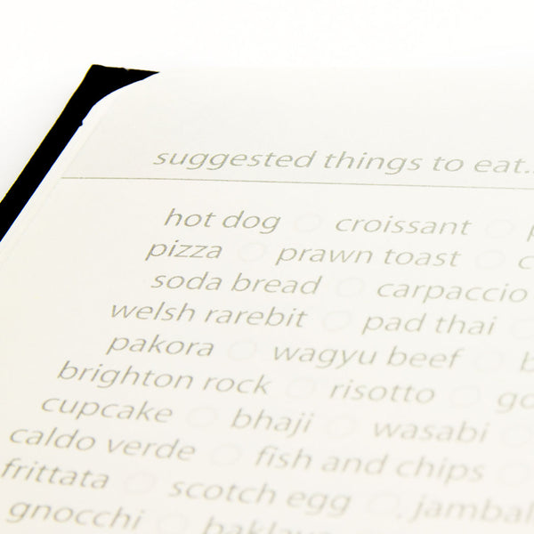Travel journal page with a list of suggested food items printed on it.
