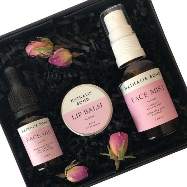 Close up of Face oil, lip balm and face mist in a black gift box