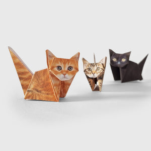 Three origami cats of different breeds on a white background