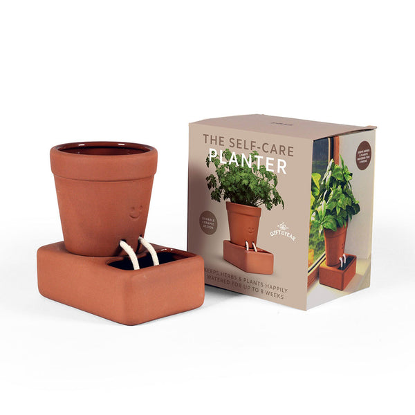 Terracotta self-care planter with its packaging on a white background