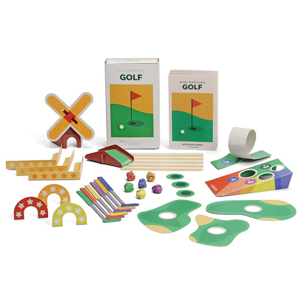 All of the pieces inside the tabletop golf game including clubs, golf balls and holes on a white background