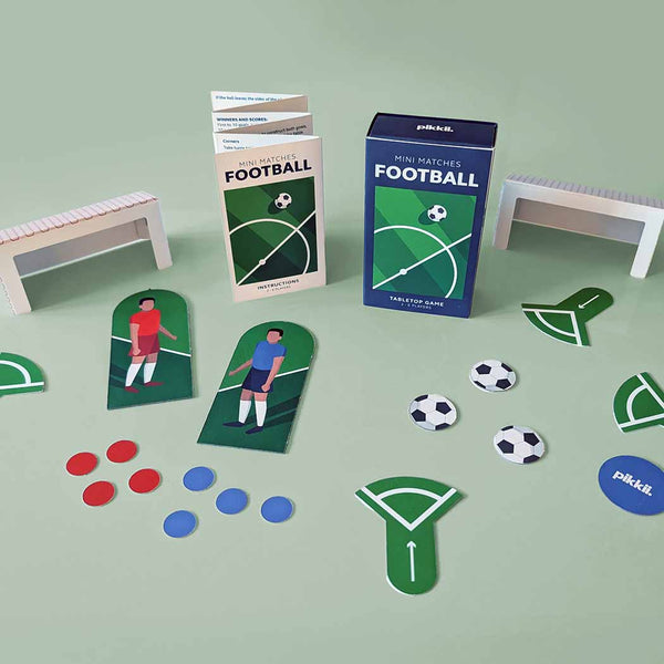 Mini soccer match game set showing players, goals and footballs on a green background