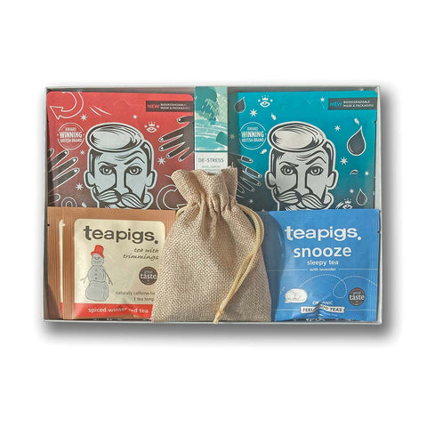 A silver grey hamper filled with face masks, chocolates, essential oil and Christmas tea temples, on a white background