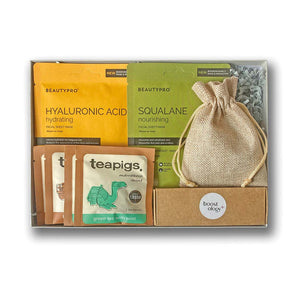 A grey hamper box containing wellness gifts