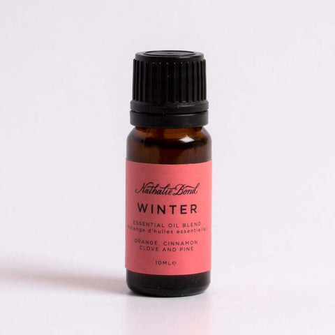 A bottle of orange, cinnamon, clove & pine essential oil, on a white background