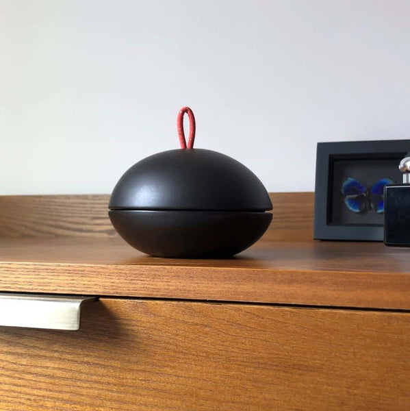 A bonbonniere jewellery box on wooden bedroom drawers