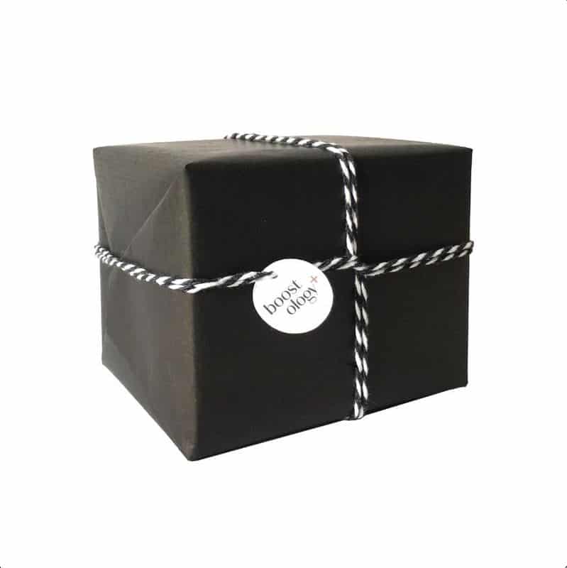 A gift wrapped in eco-friendly black kraft paper, tied with black and white string