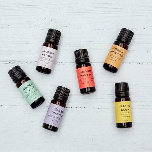 Six bottles of essential oils for diffusers, on a wooden background