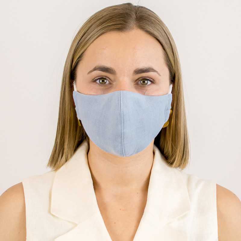 A woman wearing a blue linen 3 layer face mask