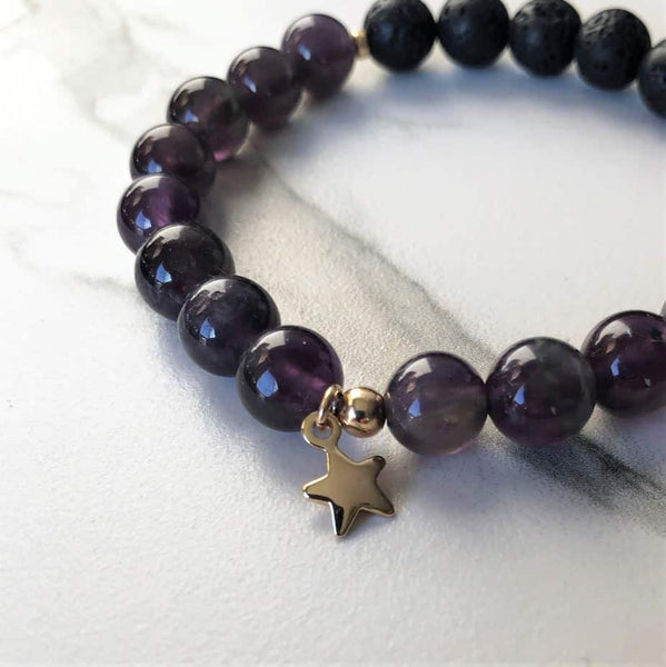 A purple amethyst beaded bracelet on a white marble background