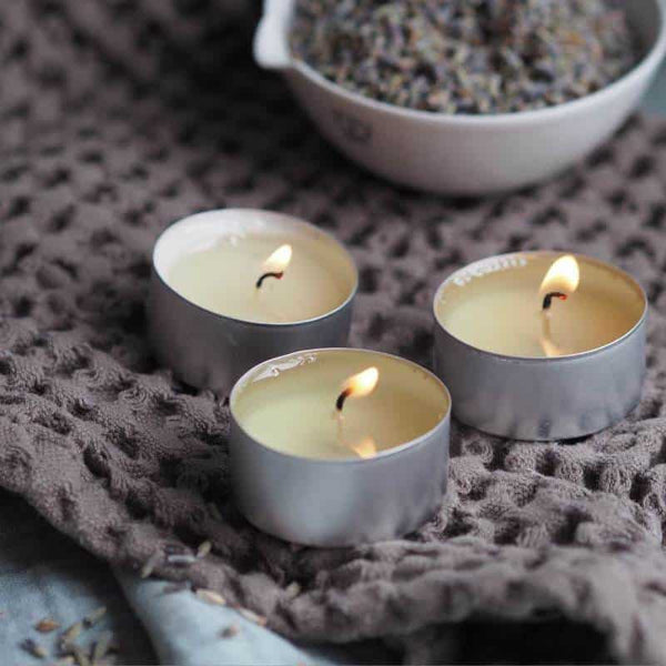 Three relaxing essential oil tea light candles with a bowl of lavendar petals