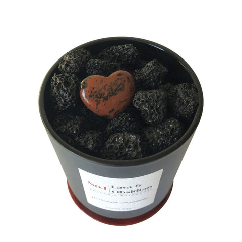 Black lava rocks and a red obsidian stone heart in a black vessel
